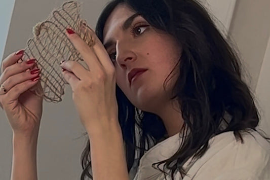 Artiste observant une matrice textile en fibre dans son atelier