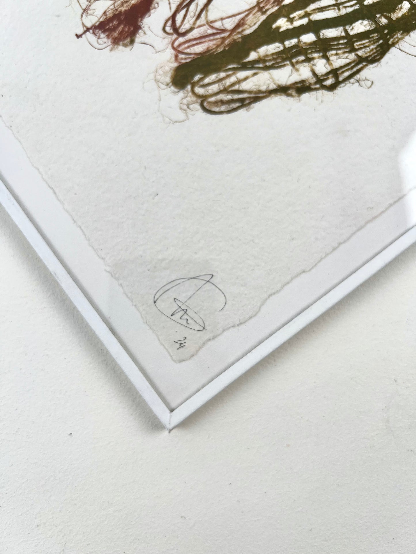 Détail d'une estampe de tissage verte et bordeaux encadrée sur papier artisanal