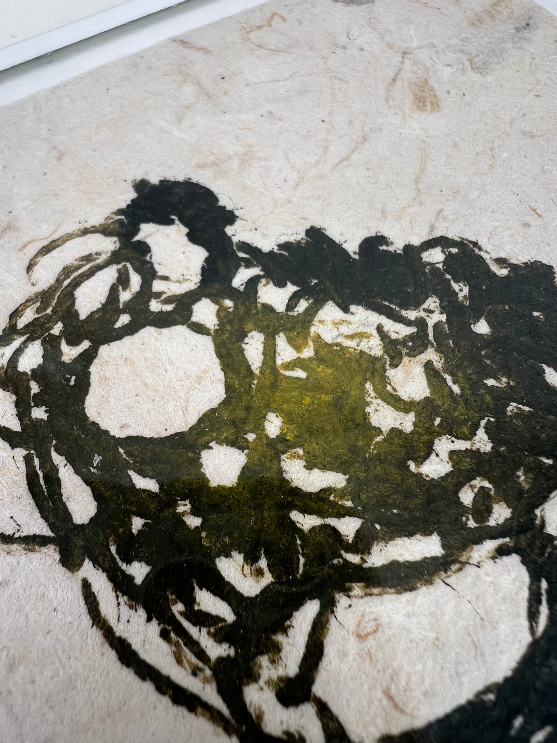 Détail de l'estampe de crochet verte encadrée sur papier texturé artisanal