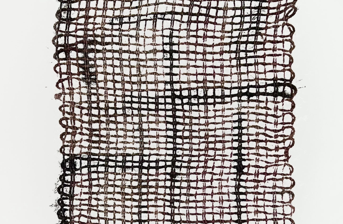 Gros plan sur l'empreinte des fibres de jute révélant la texture du tissage et les nuances de l'encrage.