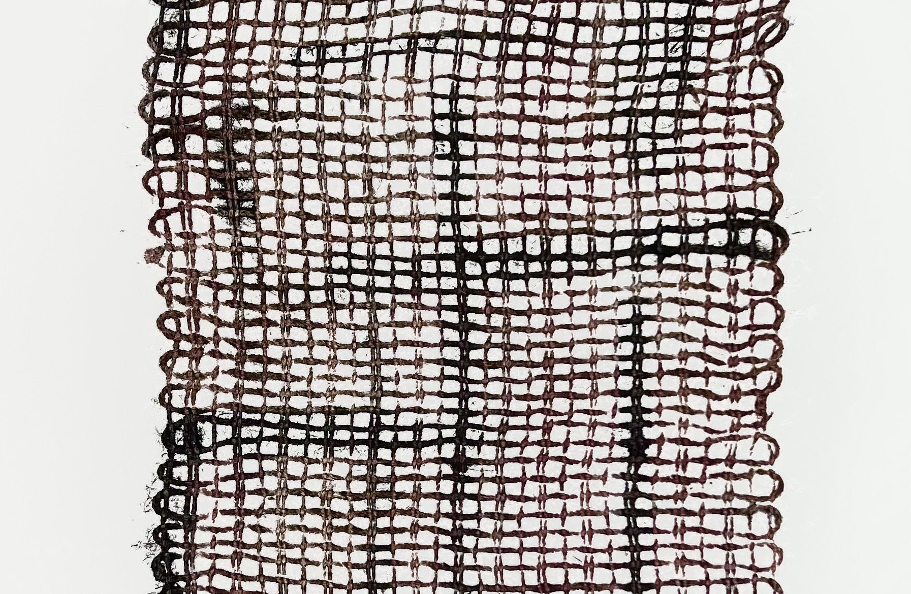 Gros plan sur l'empreinte des fibres de jute révélant la texture du tissage et les nuances de l'encrage.